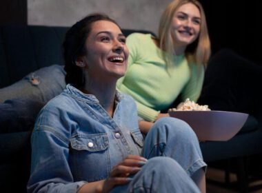 filmy na babski wieczór dwie uśmiechnięte kobiety oglądają film