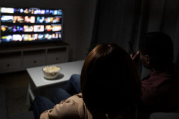 filmy na wieczór w telewizorze przed którym siedzą dwie osoby