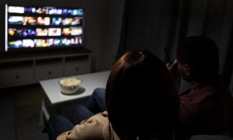 filmy na wieczór w telewizorze przed którym siedzą dwie osoby