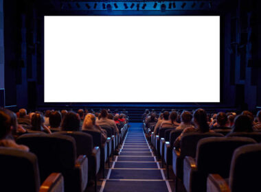pełna sala kinowa z białym ekranem